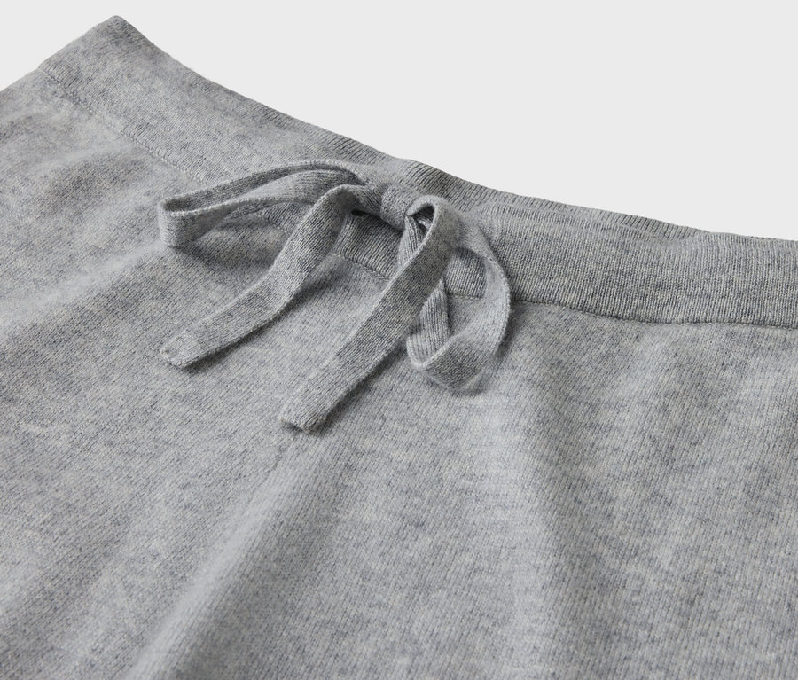Detail einer grauen Jogginghose mit Kordelzug.