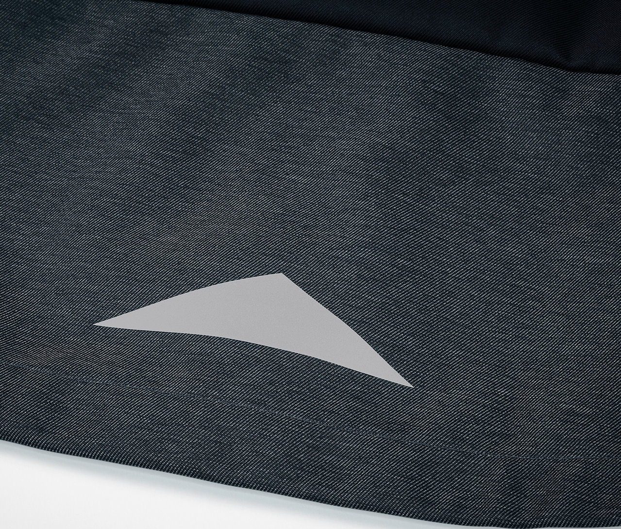 Detail einer Kinder-Softshelljacke mit reflektierendem Dreieck.