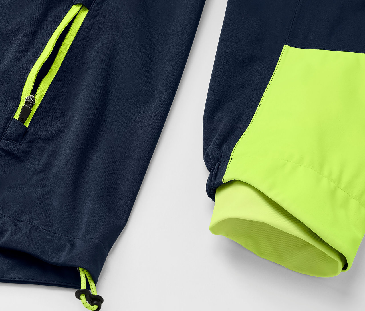 Detailansicht einer Rad-Regenjacke, marineblaue Jacke mit neongelben Reißverschluss- und Manschettendetails.