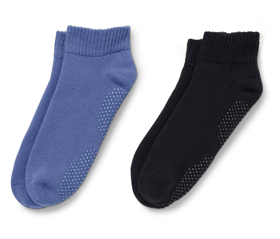 Zwei Paar Socken, ein Paar blau, ein Paar schwarz, liegen auf einem weißen Hintergrund.