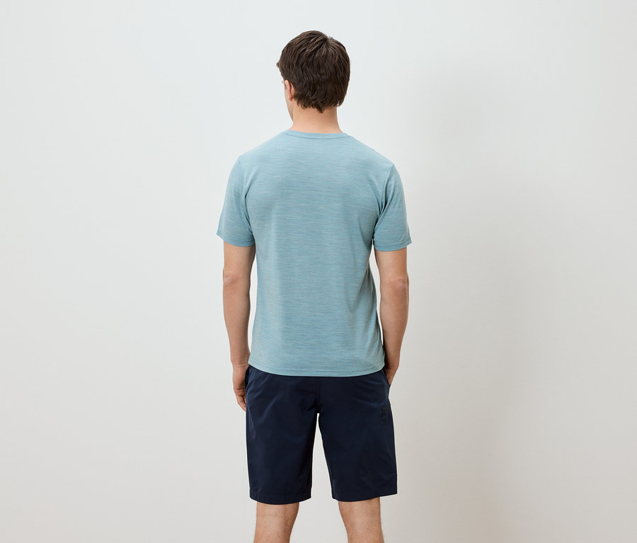 Ein Mann von hinten, mit hellblauem T-Shirt und blauen Shorts.