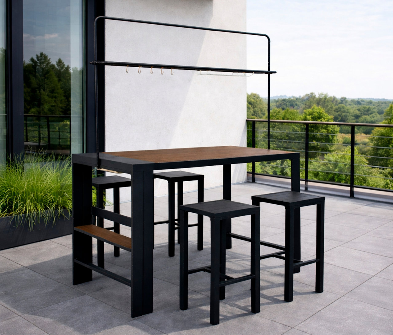 Der Leco Bartisch mit vier Hockern steht auf einer Terrasse vor Bäumen.