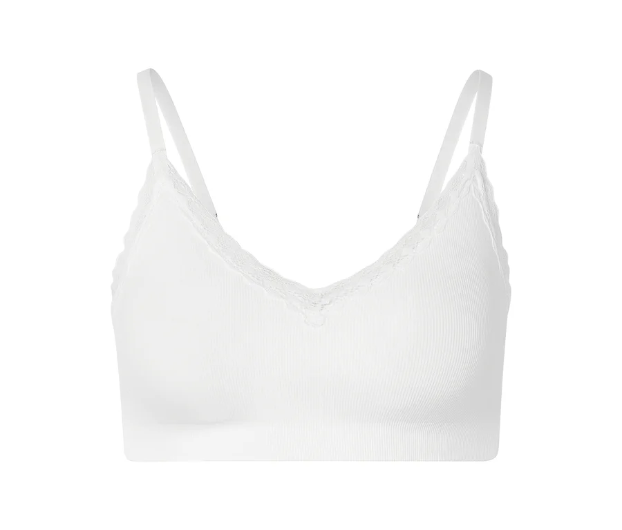 Weißes, geripptes Bralette mit Spitze und verstellbaren Trägern vor weißem Hintergrund.