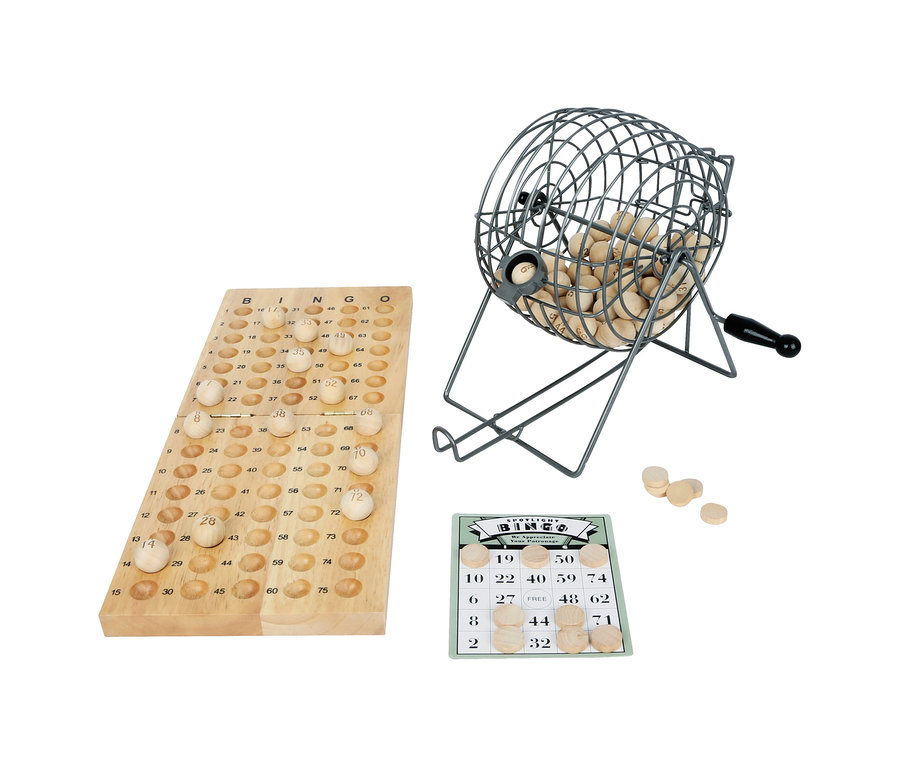 small foot Bingo-Spiel Set mit Holzbrett, Metallkäfig voller Holzkugeln, einer grün-weißen Bingokarte und losen Holzmarkern. Das Holzbrett hat nummerierte Felder, einige mit Kugeln gefüllt. Der Metallkäfig hat einen schwarzen Griff und eine Kugel im Auswurf. Die Bingokarte zeigt Zahlen, einige mit Holzmarkern bedeckt.