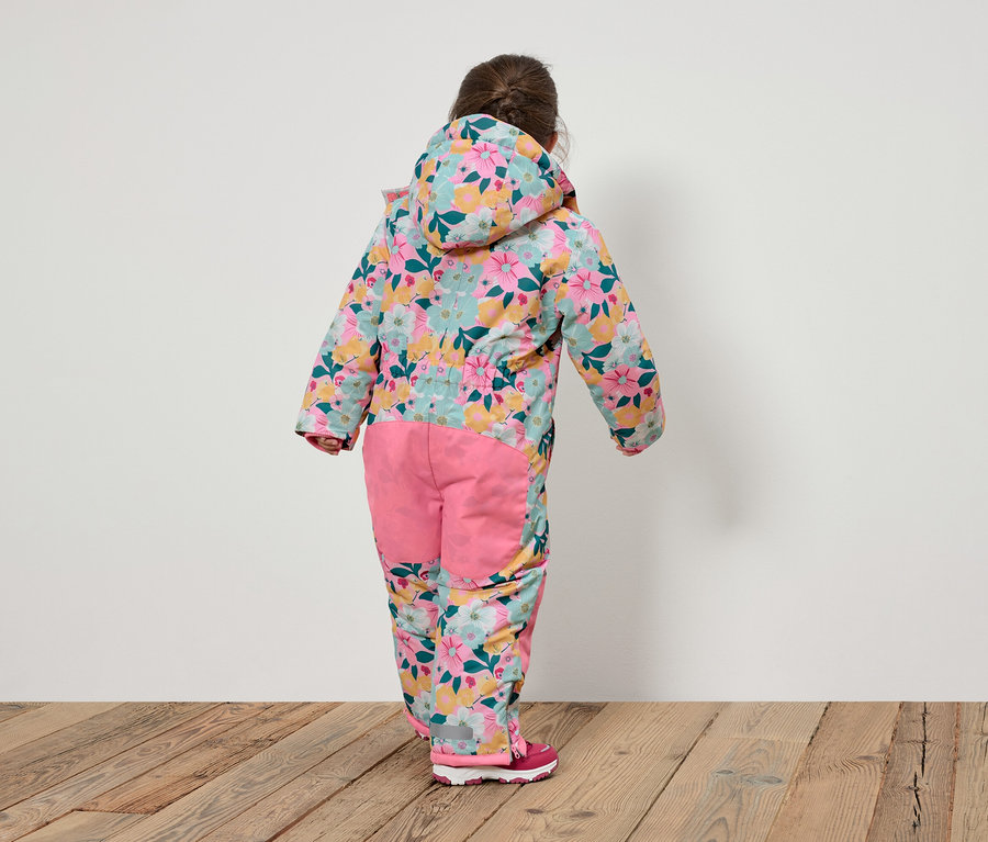 Rückansicht eines Kindes in einem geblümten Overall mit Kapuze und rosafarbener Hose.