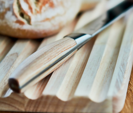 Brot und Ballarini Brotmesser »Tevere« auf einem Holzbrett.
