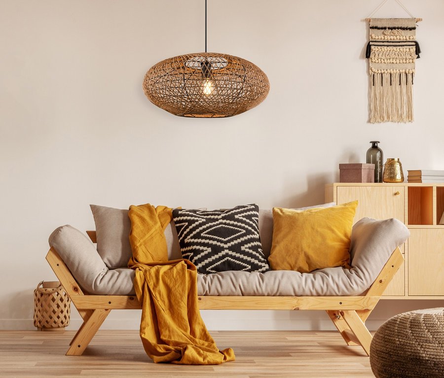 Wohnzimmer mit beigem Sofa mit Kissen und brauner Trio Pendelleuchte »Hedda« aus Geflecht.