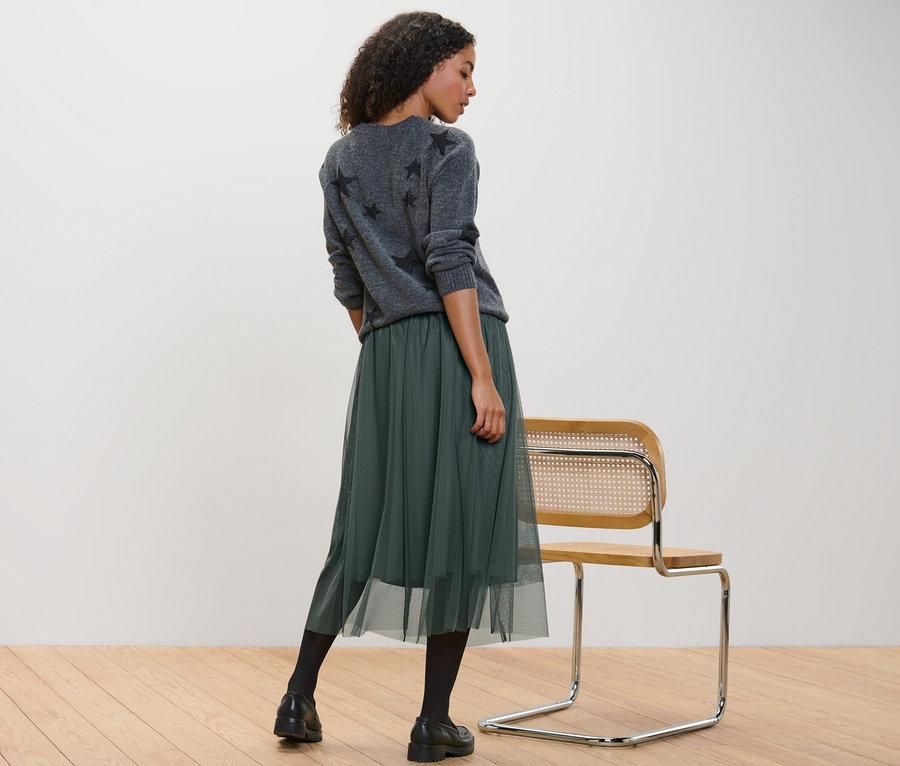 Frau steht und trägt einen Tüllrock.