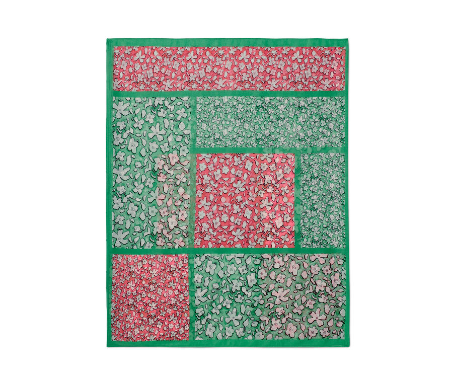 Detailansicht eines bedruckten Loop-Schals mit Blumenmuster in Grün und Rosa.