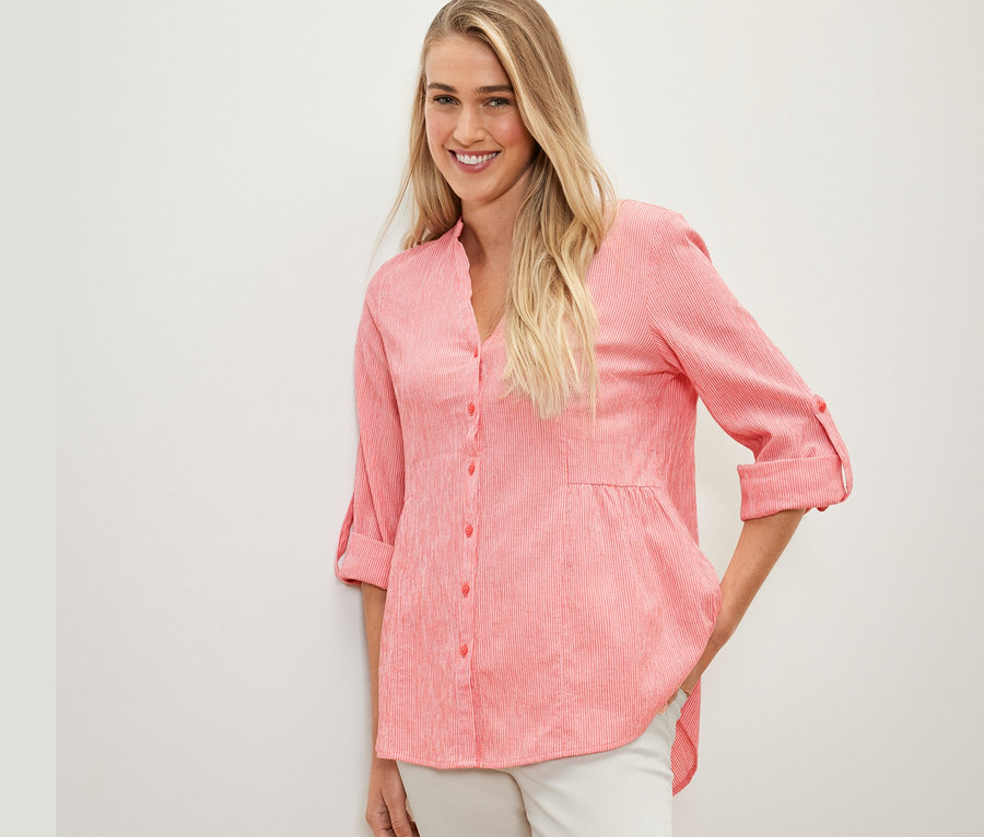 Frau posiert in gestreifter Longtunika, koralle.