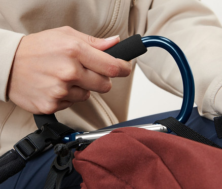 Person hält einen blauen 2 XXL-Karabinerhaken, der an einem braunen Rucksack befestigt ist.