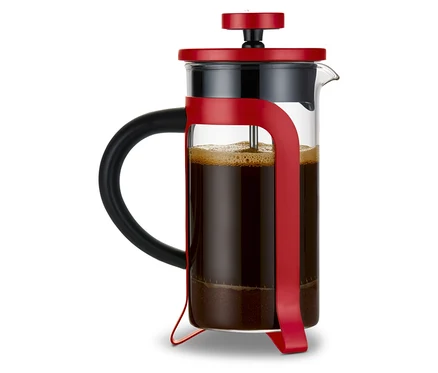 Eine rote Siebstempelkanne mit 300 ml Fassungsvermögen und 2 Tassen, gefüllt mit Kaffee. Im Hintergrund ist ein Geschenkset "Liebe-To-Go" zu sehen.