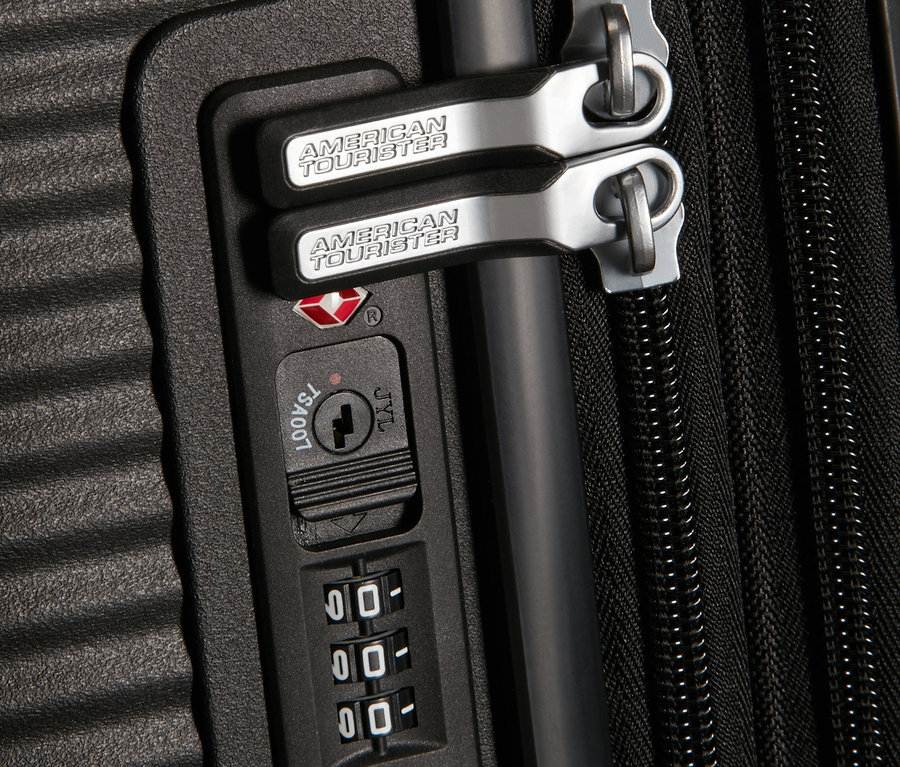 Detailansicht eines schwarzen American Tourister Soundbox Hartschalen-Koffers mit Zahlenschloss.