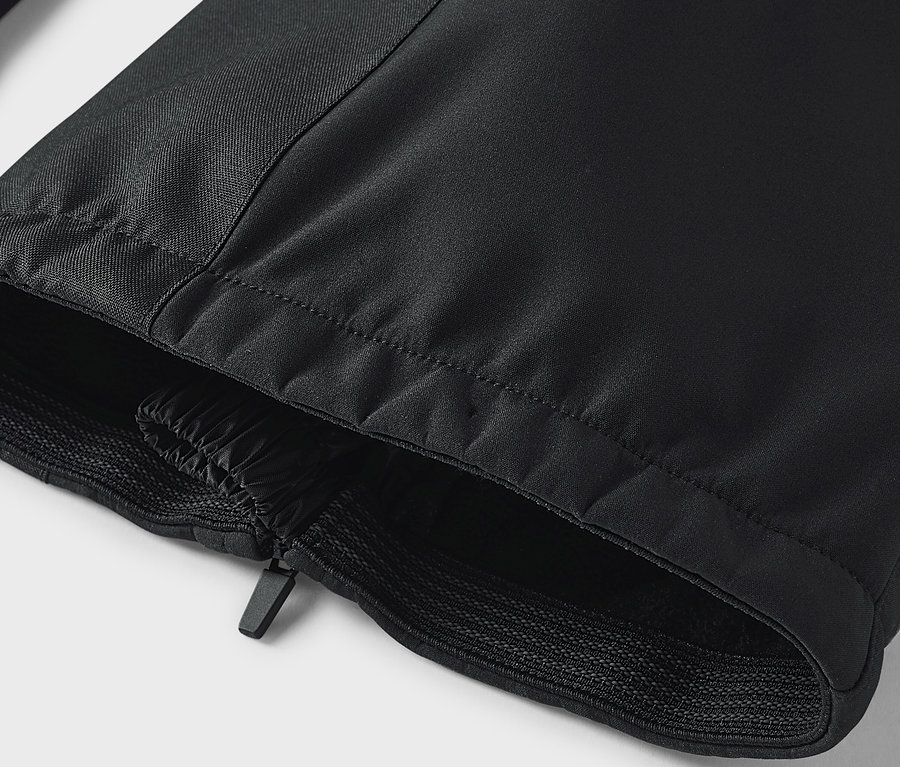 Detail einer schwarzen Hose mit Reißverschluss und elastischem Saum.