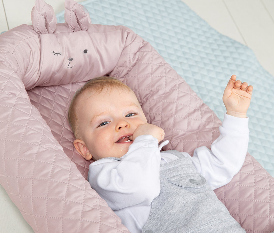 Baby liegt in rosa Roba Babylounge.