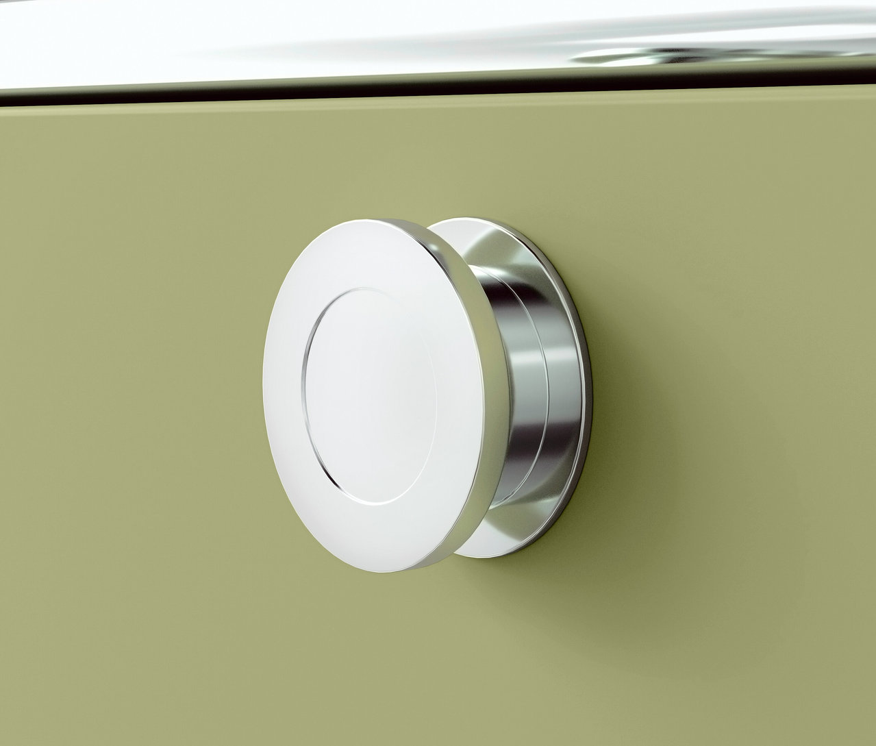 Detailansicht eines runden Chromgriffs an einem grünen Schrank.