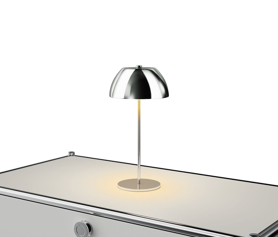 Silberfarbene Lampe auf einem weißen Tisch.