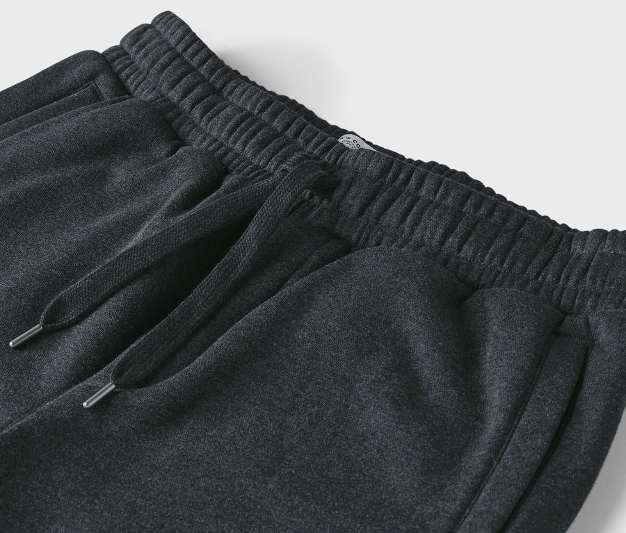 Detailaufnahme einer dunkelgrauen Jogginghose mit Kordelzug und elastischem Bund.