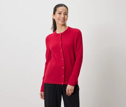 Frau trägt eine rote Strickjacke und eine schwarze Hose.