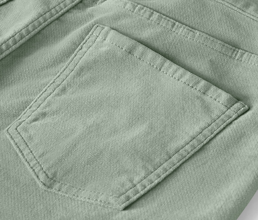 Detail einer Gesäßtasche hellgrüner Hosen.