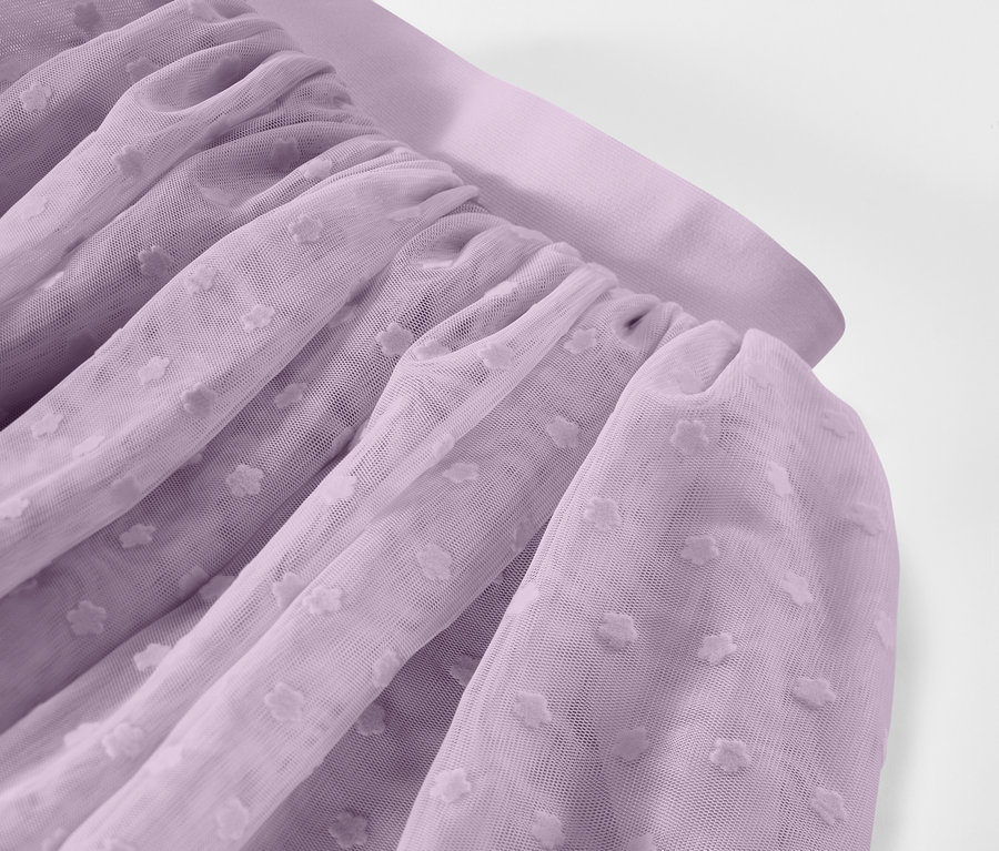 Nahaufnahme von gerafftem, lavendelfarbenem Tüllstoff mit gepunktetem Muster.