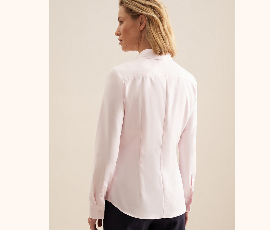 Frau trägt eine roséfarbene Seidensticker Twillbluse.