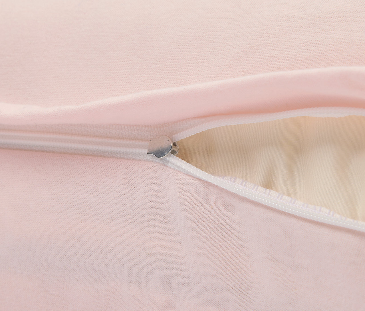 Detail eines rosafarbenen Kissens mit silbernem Reißverschluss.