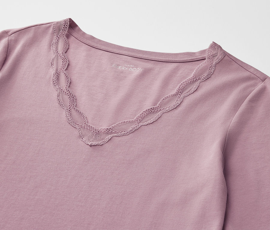 Detailaufnahme eines lilafarbenen Langarmshirts mit V-Ausschnitt und Spitzenbesatz.