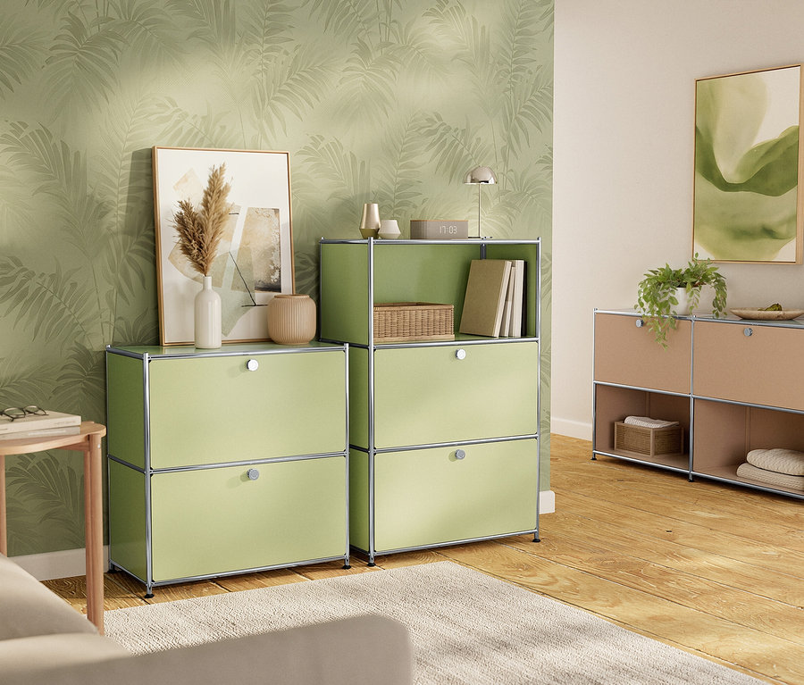 Zwei grüne und ein beiger Schrank stehen auf einem Holzboden vor einer Wand mit Blättermuster.