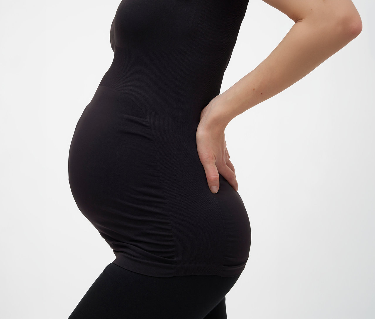 Schwangere mit schwarzem MAMALICIOUS Tanktop »MLHEAL« in Einheitsgröße und Leggings, Hand auf dem Rücken.
