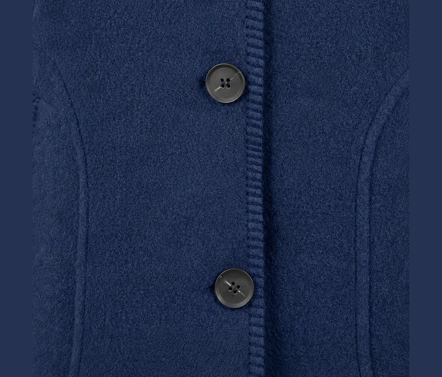 Blauer Wollmantel mit zwei dunklen Knöpfen an einer gerippten Knopfleiste.