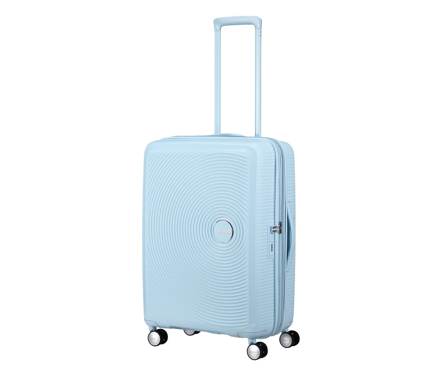 American Tourister Soundbox Hartschalen-Koffer in Pastellblau, mittelgroß, mit konzentrischen Rillen, ausgefahrenem Teleskopgriff und vier Rollen.