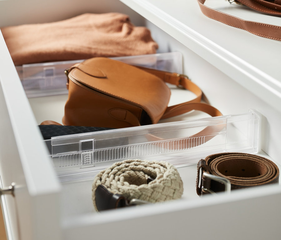 Offene Schublade mit 2 Schubladentrennern, Pullover, Handtasche und Gürteln.