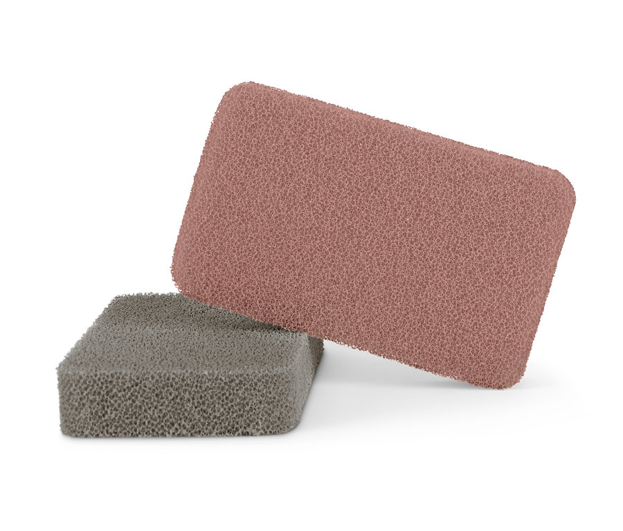 Zwei Silikonschwämme, einer in Taupe und einer in Malve, liegen übereinander.