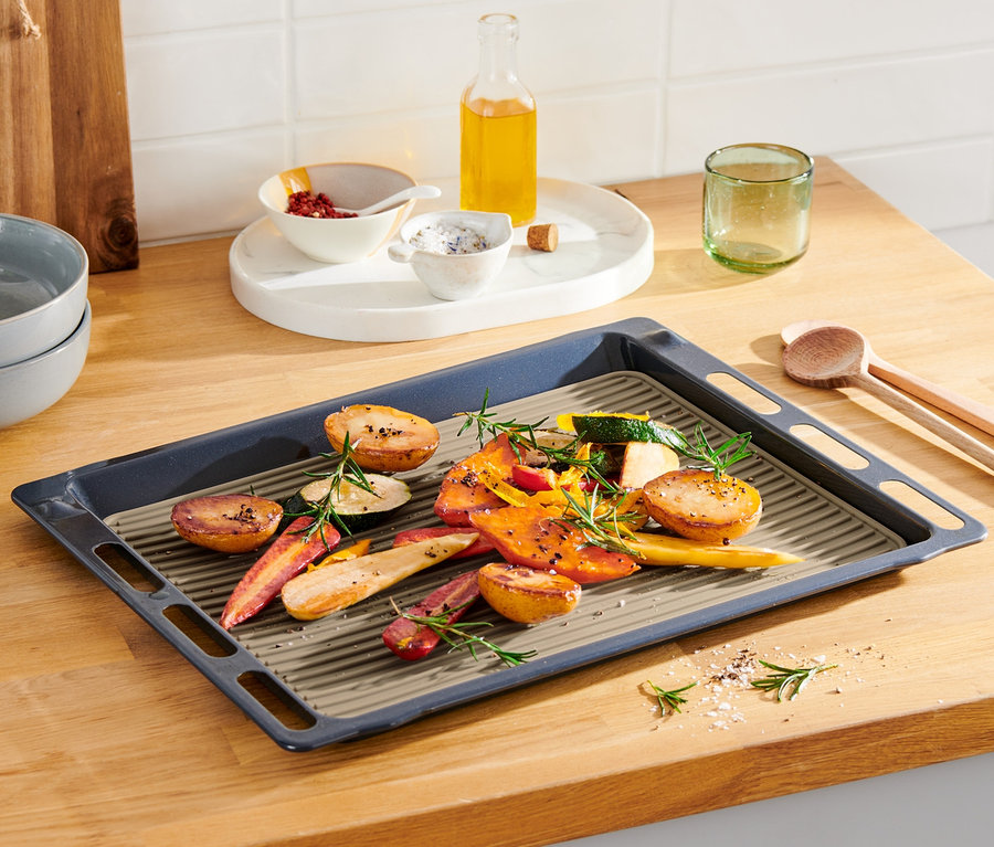 Geröstete Kartoffeln, Karotten und Zucchini auf einer doppelseitigen Dauerbackmatte auf einem Backblech.