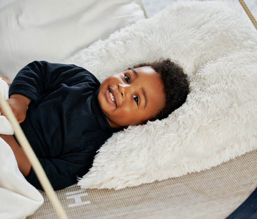 Ein Kind liegt in einer HUDORA Nestschaukel »Lounge«, midnight.