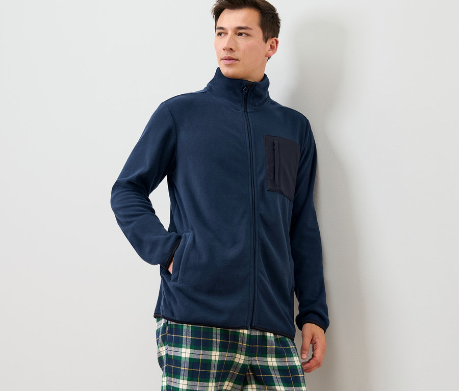 Mann trägt eine Fleece-Jacke und eine karierte Hose.
