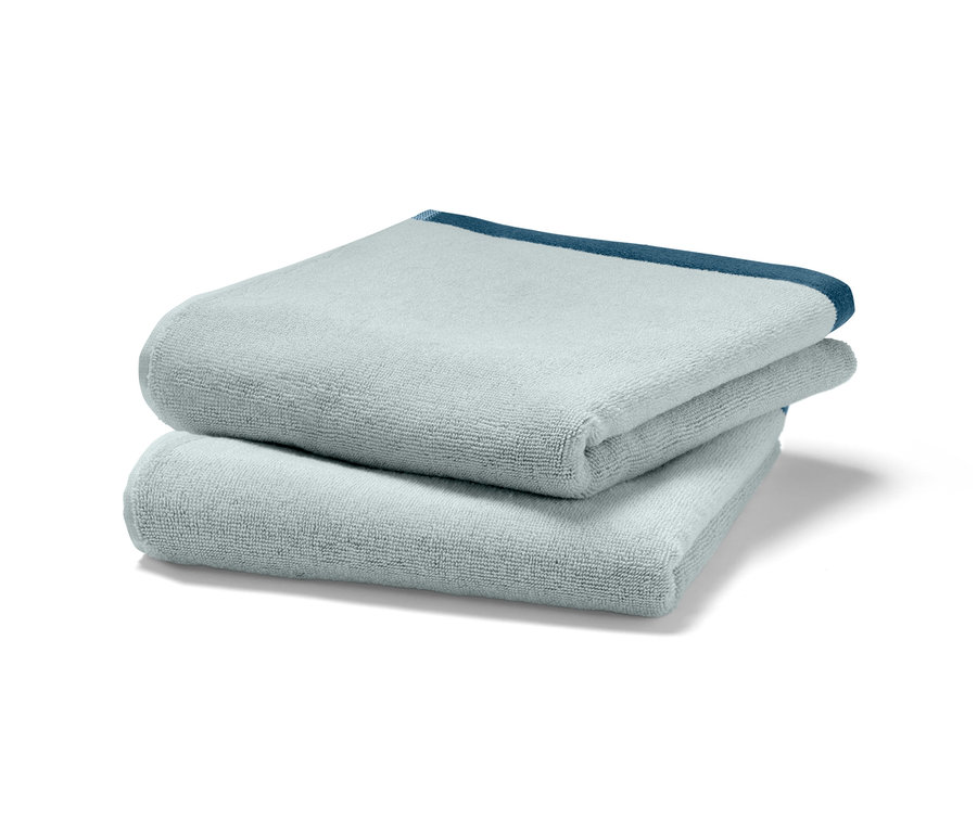 Zwei blaue Jacquard-Handtücher liegen übereinander.
