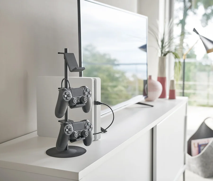 Auf einer weißen Kommode steht ein schwarzer YAMAZAKI Controller-Ständer »SMART« mit zwei Controllern.