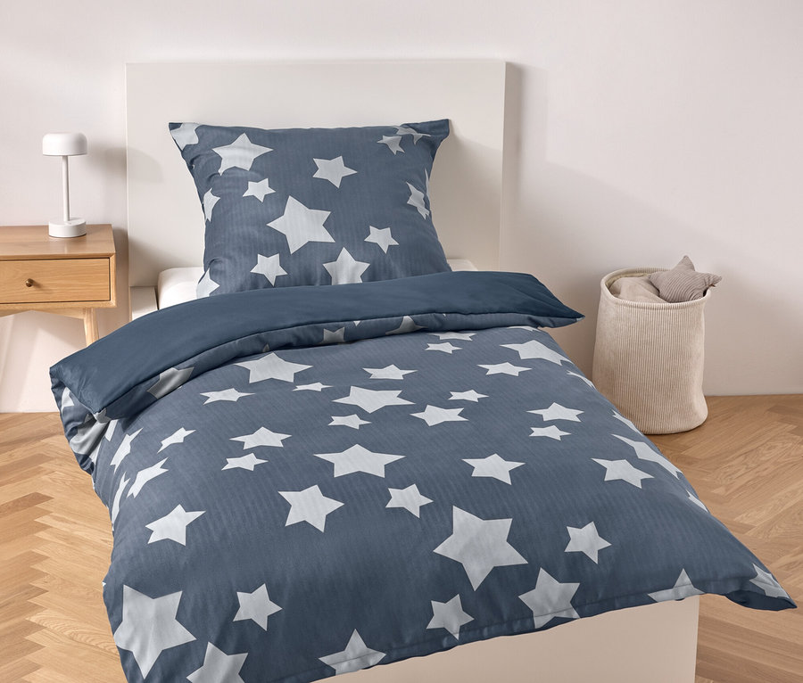 Blaue Bettwäsche mit Sternen auf einem Bett.