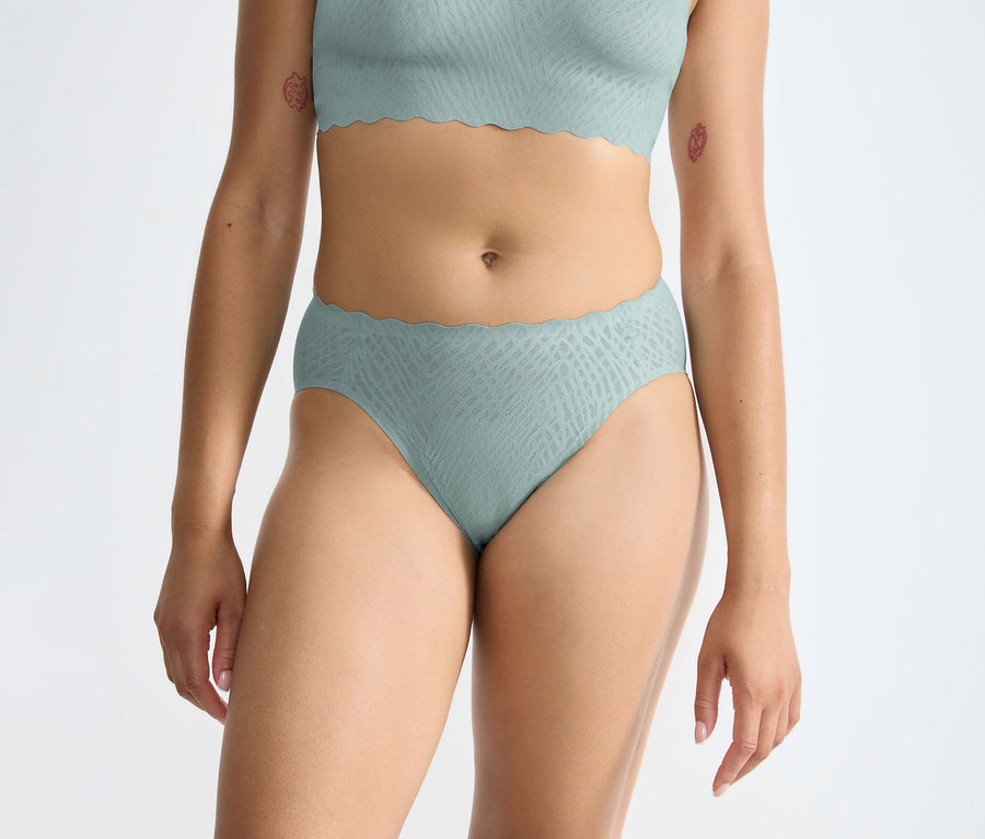 Person trägt einen misty turquoise sloggi ZERO Feel Bliss High leg Slip und einen passenden BH mit Wellenkanten.