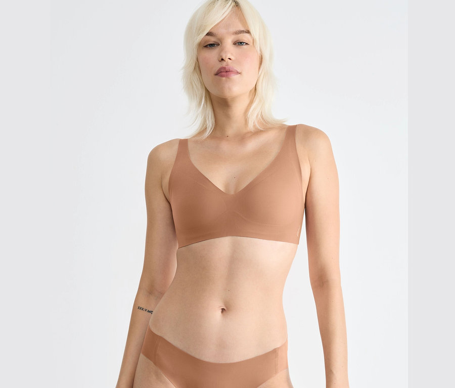 Blonde Frau trägt einen braunen sloggi ZERO Feel 2.0 Soft BH.