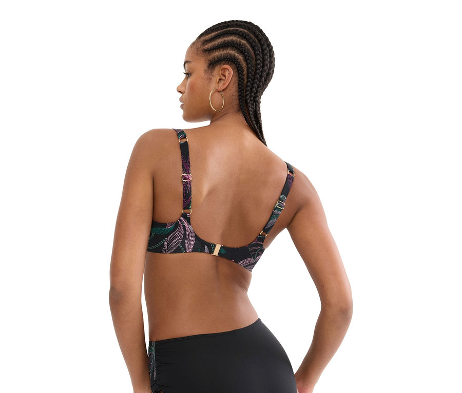 Frau von hinten, die einen schwarzen Bikini mit Pflanzenmuster und schwarze Bikinihose trägt.