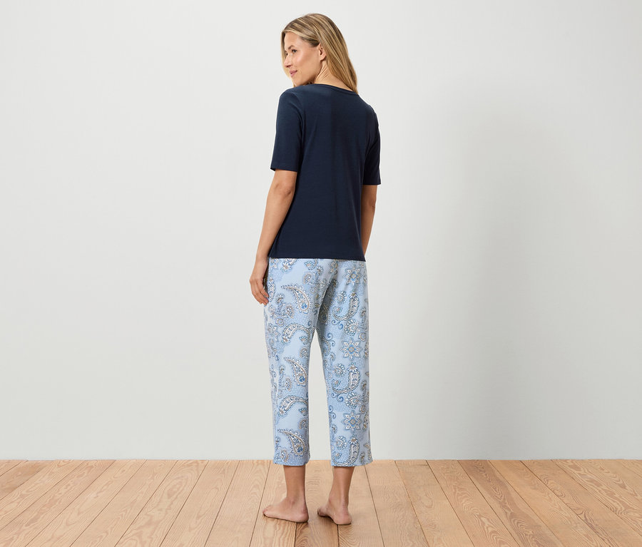 Frau von hinten in marineblauem T-Shirt und hellblauer Hose mit Paisleymuster.