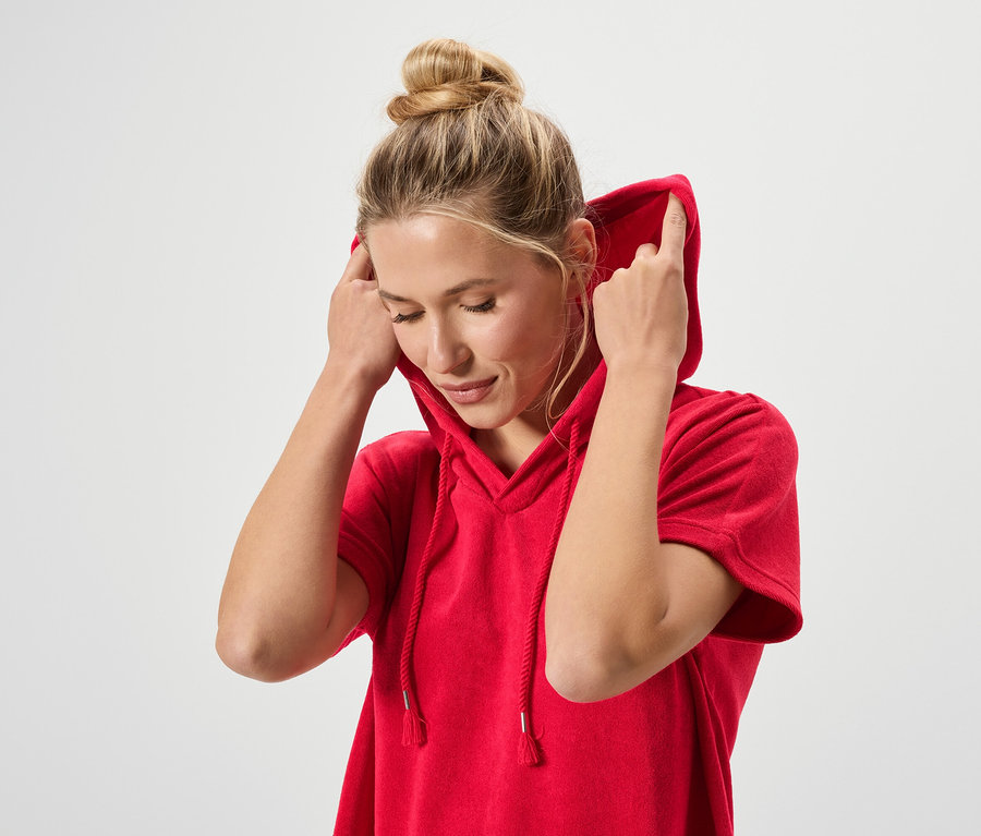 Frau mit Dutt trägt einen roten Kapuzenpulli.