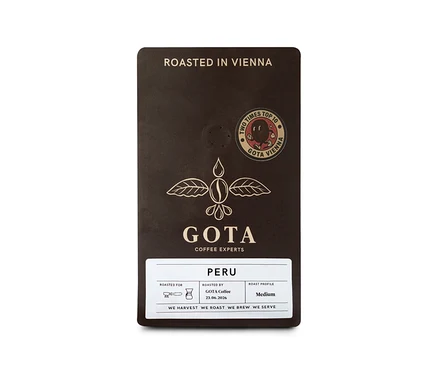 Dunkelbraune Gota Coffee Peru Omni-Roast 250 g Ganze Bohne Kaffeepackung mit goldenem Logo eines geflügelten Kaffeebohnen-Tropfens, einem "ROASTED IN VIENNA"-Schriftzug und einem "TWO TIMES TOP 10"-Abzeichen.