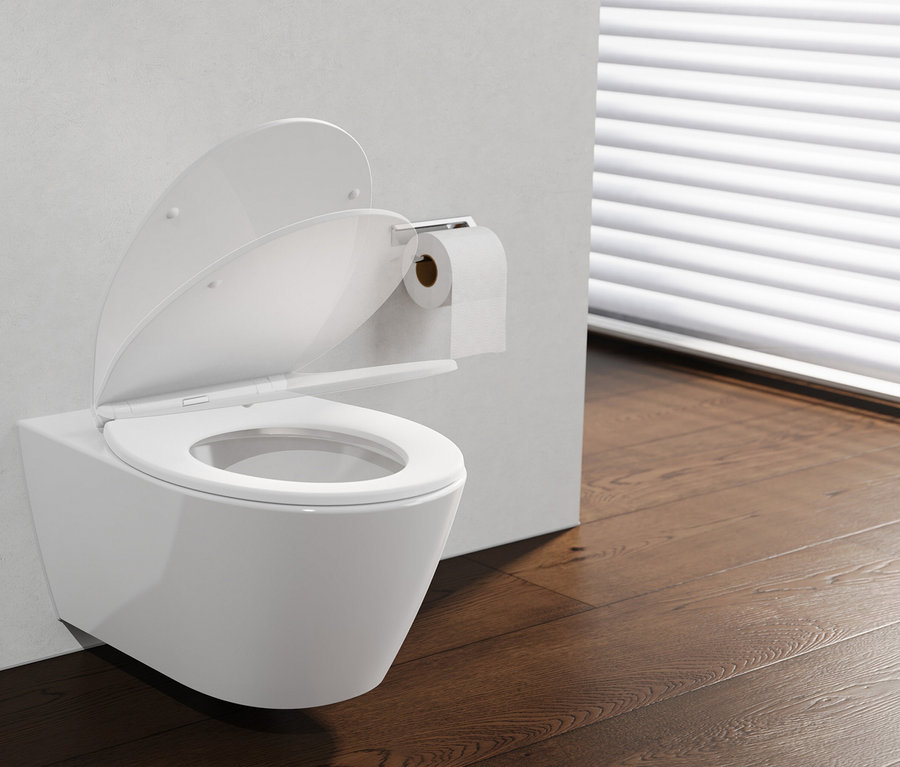 Weißes wandhängendes WC mit geöffnetem WC-Sitz „PREMIUM“ und Deckel, daneben ein Toilettenpapierhalter mit Rolle, auf dunklem Holzboden vor einem Fenster mit weißen Jalousien.