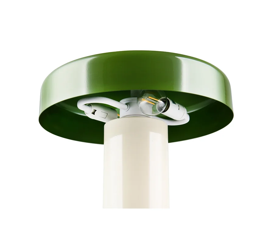 Nahaufnahme einer Lampe mit einem runden, grünen Schirm und einem cremefarbenen zylindrischen Sockel. Unter dem Schirm sind zwei Glühbirnen und Fassungen sichtbar.