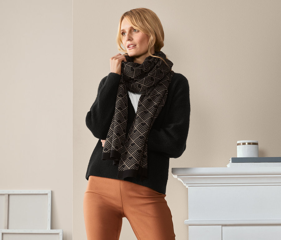 Frau posiert mit Strickschal mit Glitzergarn.