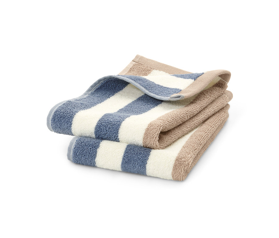Zwei hochwertige, blau-weiß-beige gestreifte Gästehandtücher liegen gefaltet übereinander.